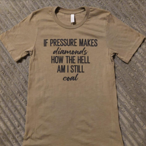 T-shirt says "if pressure makes diamonds how the hell am I still coal?"