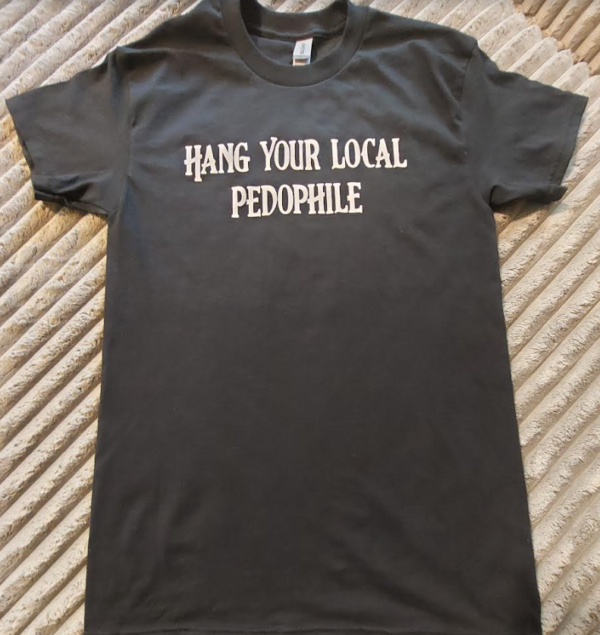 T-shirt laying flat for display says "hang your local pedophile"